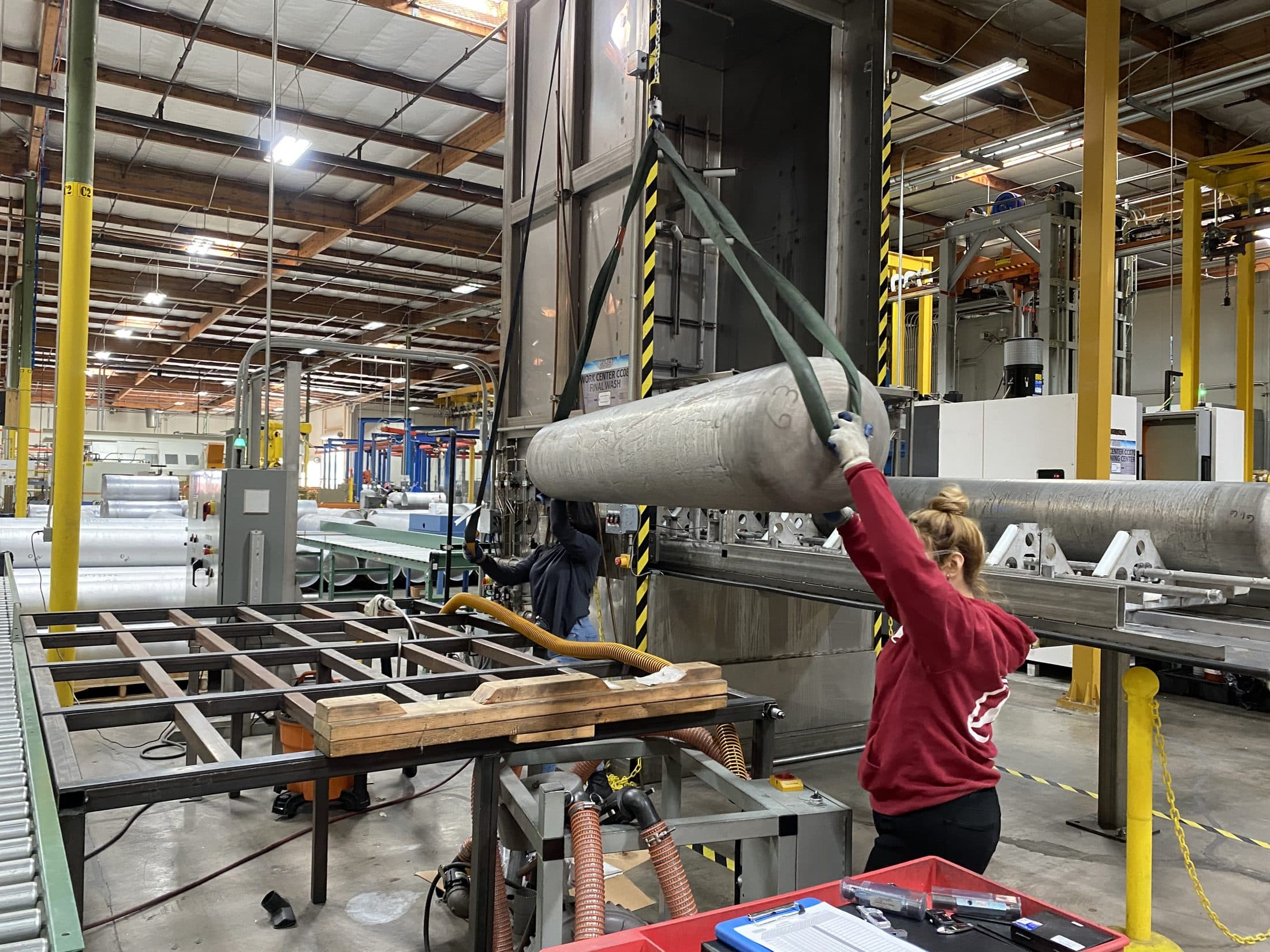An Uttam worker handling a high-pressure cylinder on the line